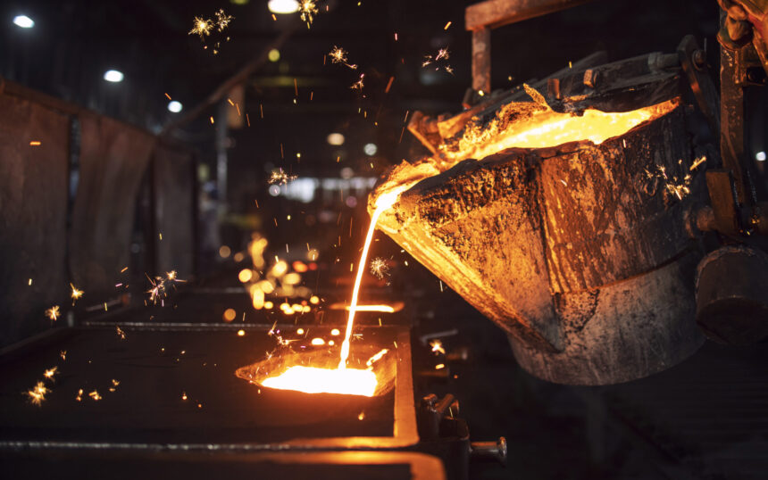 Molten metal casting in foundry. Filling mold with hot liquid iron and producing iron components in steel plant.