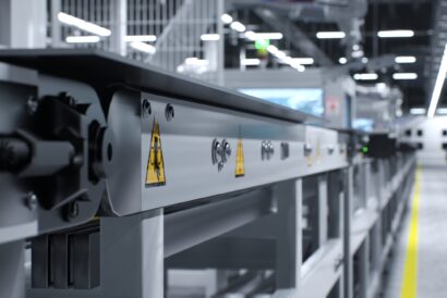 High voltage danger signs on conveyor belts in green technology factory used to produce solar panels. Safety measures stickers on assembly lines operated by heavy machinery in warehouse, 3D render