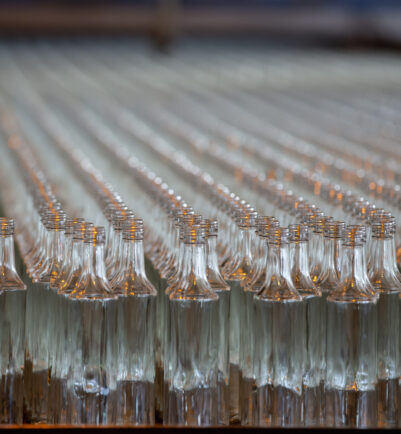 Glassworks. Glass industry. Many glass bottles on a factory conveyor.